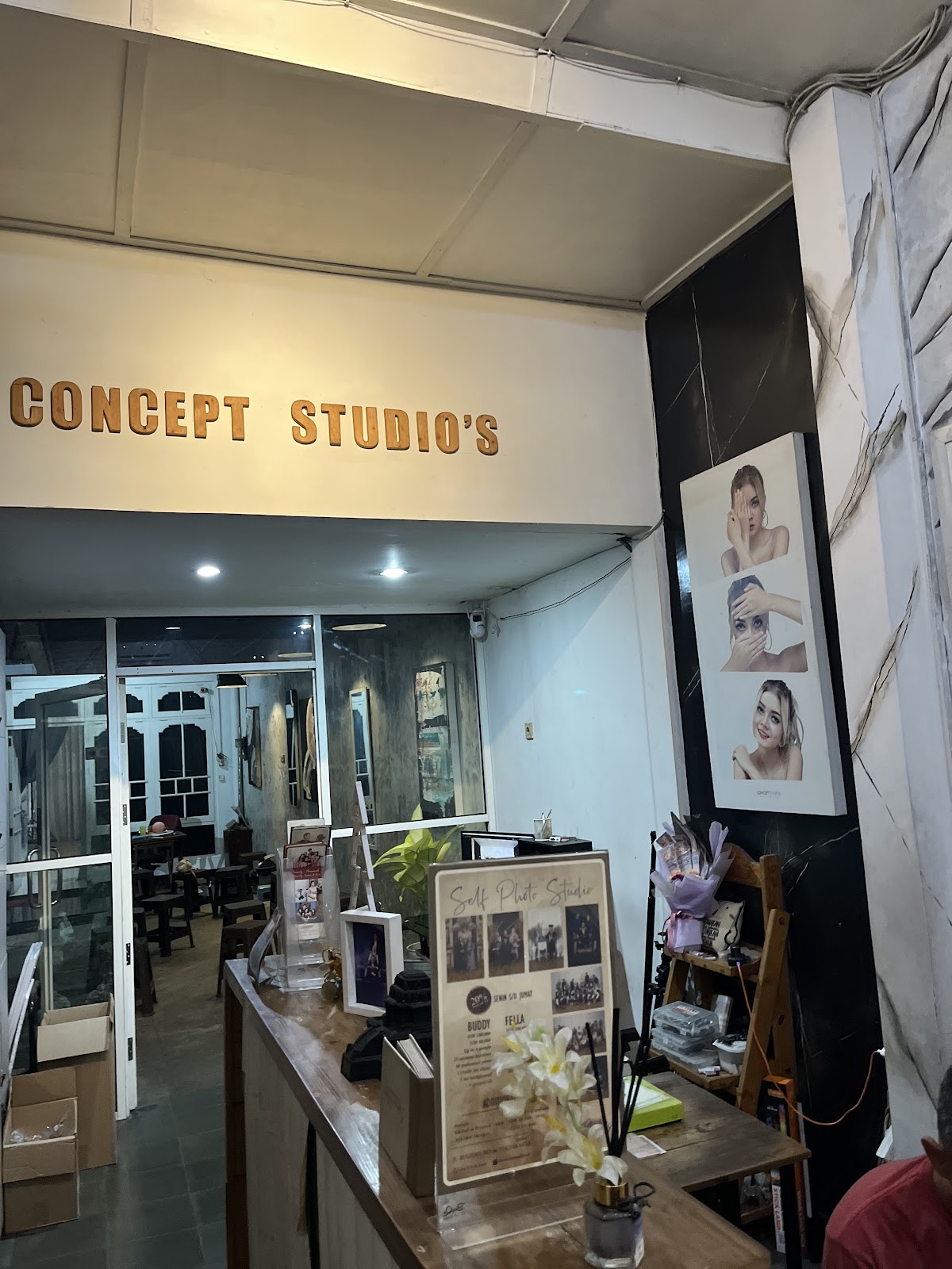 Meja penerima tamu dan tulisan CONCEPT STUDIO'S di pintu masuk