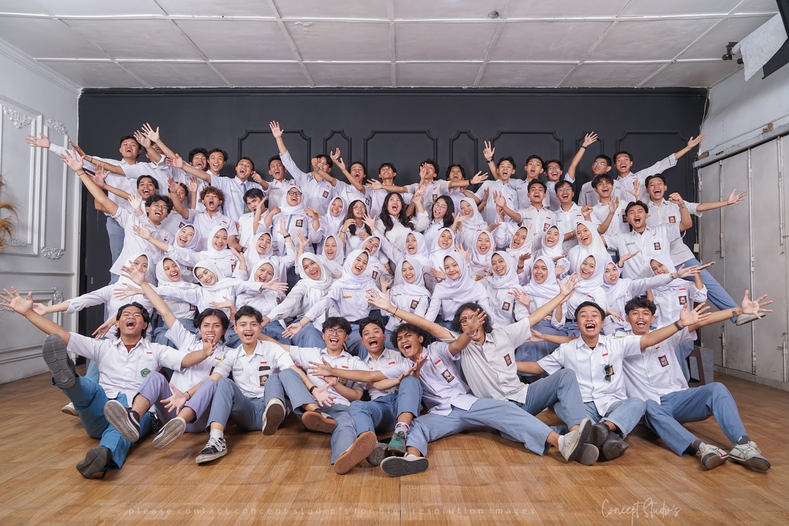 Kelompok besar berfoto bersama di set panel gelap dalam studio