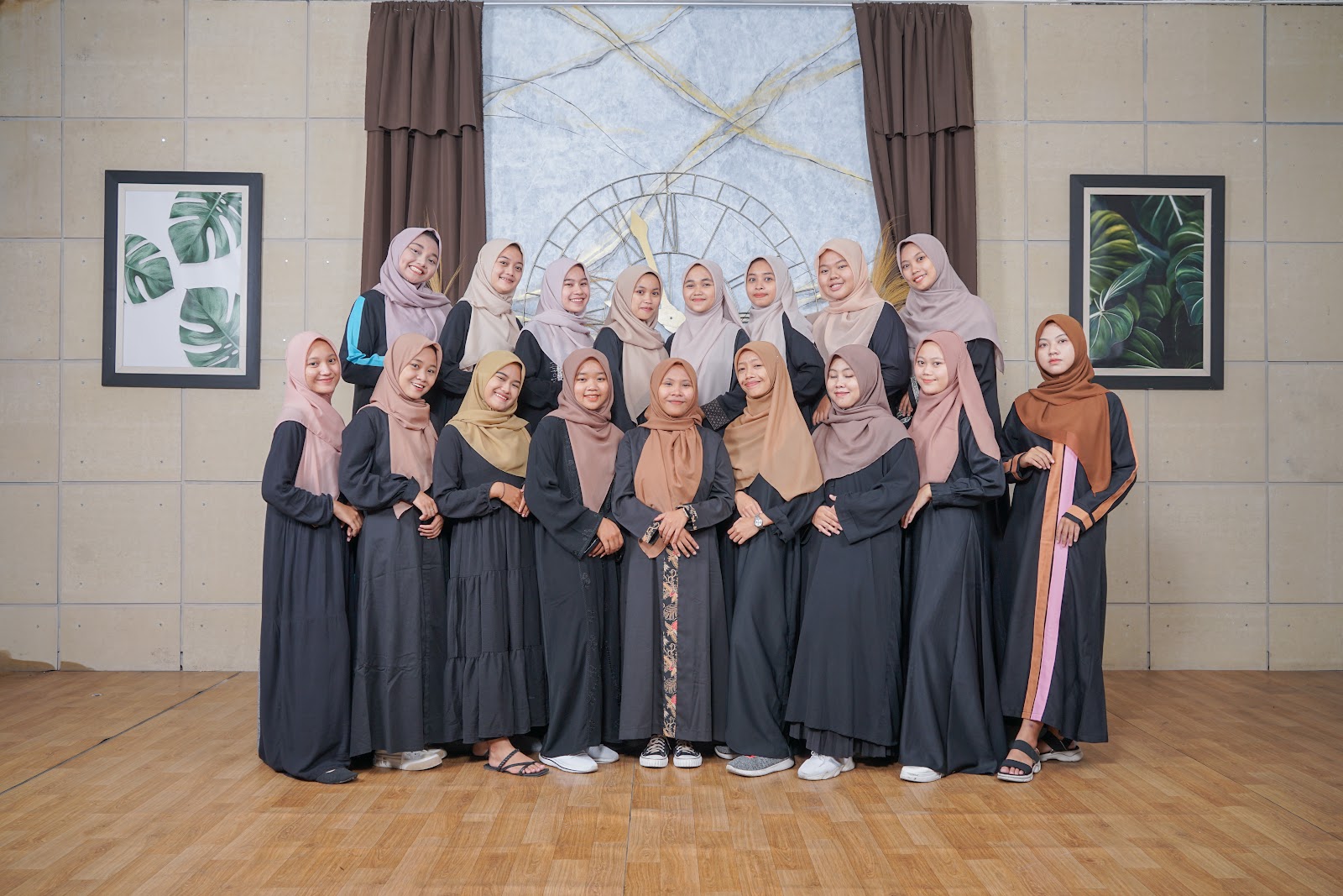 Foto grup dengan pakaian senada di depan set panel terang